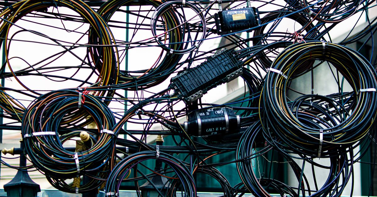 Cables de comunicación agrupados sobre una superficie metálica